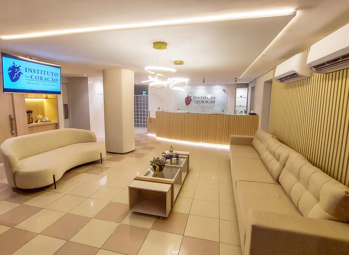 Sala de espera do Instituto do Coração, com sofás, mesa de centro e TV